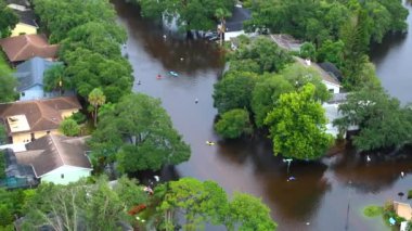 Debby Kasırgası kurbanları Florida, Sarasota 'da sel basmış bir sokakta kano kullanıyor. Yerleşim alanındaki kırsal evler arasında sağanak yağmur suları