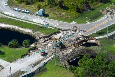 Florida 'da kasırga üstüne köprü yıkıldı. Yol çalışması alanında inşaat malzemeleri. Sel sularının asfaltı temizlemesinden sonra hasarlı yolun yeniden inşası.
