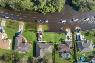 Amerikan caddesini hareket halindeki araçlarla doldurdu ve Florida yerleşim bölgesinde su evleri ile çevrili. Kasırga doğal felaketinin sonuçları..