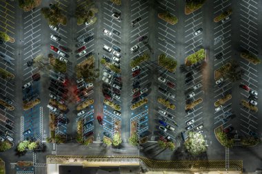 Florida 'da bir alışveriş merkezinin önündeki otoparkta park edilmiş birçok arabanın üst görüntüsü. Kentsel ulaşım kavramı.