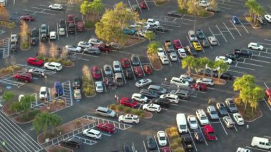 Bir marketin önündeki otoparkta park edilmiş birçok arabanın hava görüntüsü..
