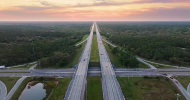 Gün batımında Florida kırsal kesiminde hızlı giden trafik arabalarıyla kavşak. ABD 'de eyaletler arası ulaşım altyapısı.