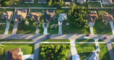 Florida 'daki küçük Amerikan kasabasında trafik arabaları süren kırsal yol. Sakin yerleşim bölgesinde yeşil ağaçlar ve banliyö sokakları arasında özel evler