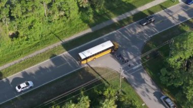 Sarı okul otobüsü, Florida 'nın banliyölerinde ders vermek için otobüs durağından okul çocuklarını alıyor. ABD 'de toplu taşıma.