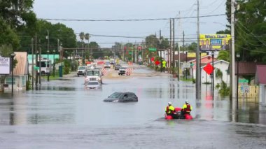 Florida yerleşim bölgesinin etrafını sularla çevrili batık araçlarla dolu yolda acil yardım ekibi. Debby Kasırgası Doğal Afet.