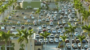 Park etmiş bir sürü arabası olan büyük bir otopark. Alışveriş merkezindeki büyük otopark. Araç yerleri ve yönleri için çizgiler ve işaretler var..
