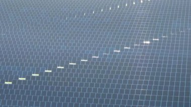 Temiz elektrik enerjisi üretmek için birçok sıra güneş fotovoltaik paneli bulunan sürdürülebilir büyük elektrik santralinin havadan görünüşü. Sıfır emisyon kavramı ile yenilenebilir elektrik.