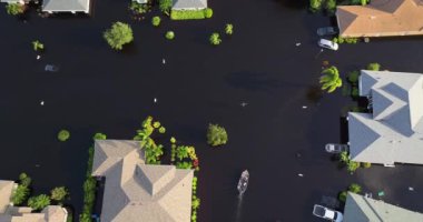 Debby kasırgasının ardından Florida, Sarasota 'da sel basmış caddelerde motorlu tekneye binen insanlar yerleşim alanındaki kırsal evleri boğdular.