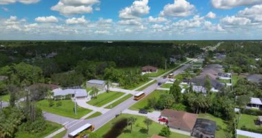 Okul otobüsü banliyö sokağında sabah erken saatlerde çocukları dersleri için alıyor. ABD 'de toplu taşıma.