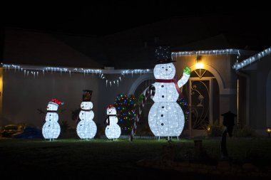 Florida aile evinin ön bahçesinde parlak ışıklandırılmış noel süslemeleri. Kış tatili için dışarıda dekor.
