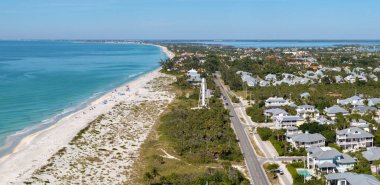 Pahalı rıhtım evleri ve okyanus kıyısında beyaz Boca Grande deniz feneri. Florida 'nın güneybatısındaki Gasparilla Adası' nda küçük bir kasaba. ABD 'de birinci sınıf konut geliştirme.