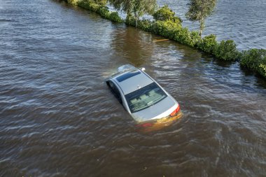 Florida yerleşim bölgesinin etrafını sularla çevrili batık arabayla dolu bir yol. Debby Kasırgası Doğal Afet.