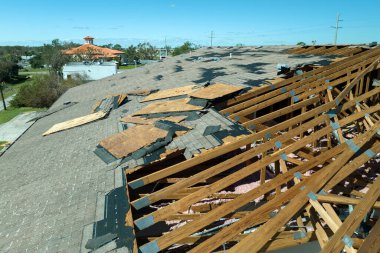 Tamire ihtiyacı olan harap bir çatı. Florida 'daki Ian kasırgasından sonra asfalt kiremitleri kaybolan rüzgârlı ev çatısı..