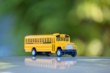 Small model of american yellow school bus as symbol of education in the USA.