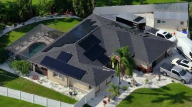 Banliyö bölgesinde temiz ekolojik elektrik üretimi için özel evin güneş çatısı fotovoltaik panellerle kaplı. Enerji tasarrufu için özerk eve yatırım yapma kavramı.