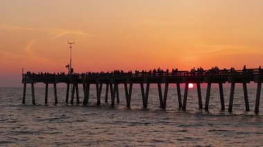 Venedik, Florida. Deniz kenarındaki yaz etkinlikleri. Birçok turist balıkçı iskelesinde gün batımının keyfini çıkarıyor.