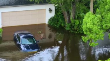 Kasırga yağmuru yolu sular altında bıraktı. Florida 'da bir evin önünde boğulmuş bir araba. Kasırga doğal felaketinin sonuçları.