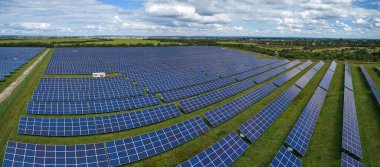 Temiz elektrik enerjisi üretmek için birçok sıra güneş fotovoltaik paneli bulunan sürdürülebilir büyük elektrik santralinin havadan görünüşü. Sıfır emisyon kavramı ile yenilenebilir elektrik.