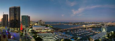 Geceleri Amerikan şehir manzarası. Bayside Pazarı 'ndaki Miami Gözlem Çarkı. Biscayne Körfezi suları ve Brickell' in yüksek aydınlatmalı gökdelenleri, finans merkezi..
