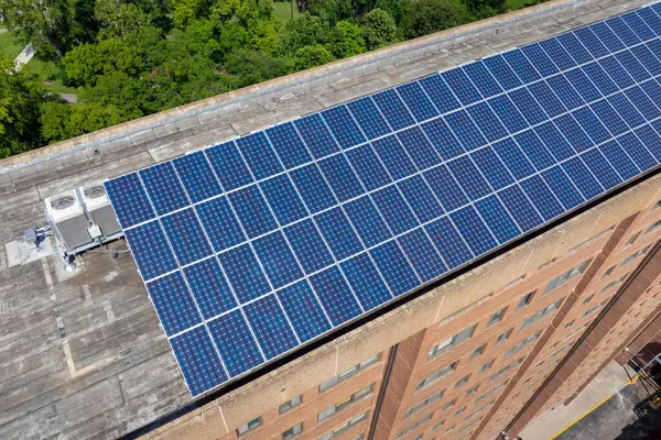 Solar çatılı bir apartman. Temiz ekolojik elektrik enerjisi üretmek için mavi fotovoltaik paneller. Yenilenebilir elektrik kavramına yatırım.