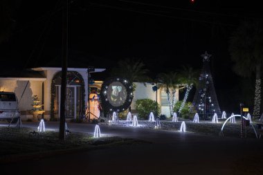 Florida aile evinin ön bahçesinde parlak ışıklandırılmış noel süslemeleri. Kış tatili için dışarıda dekor.