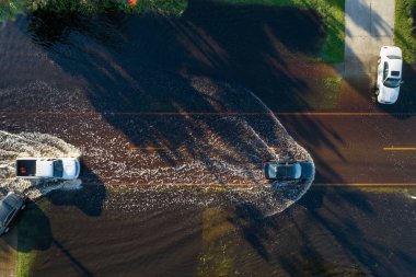 Amerikan caddesini hareket halindeki araçlarla doldurdu ve Florida yerleşim bölgesinde su evleri ile çevrili. Kasırga doğal felaketinin sonuçları..