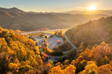 Large truck stop with resting area in North Carolina Appalachian mountains and busy American interstate freeway with fast driving cars and trucks. Recreational parking place during interstate travel. clipart