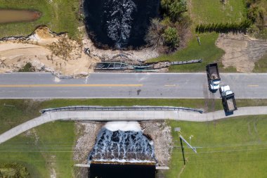 Florida 'da kasırga sonrası yıkılan köprünün tamiri. Su baskınından sonra hasarlı yolun yeniden inşası asfaltı yıkadı. Yol çalışması alanında inşaat kamyonları.