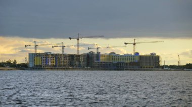 Yüksek konutlu apartman şantiyesinde vinç kaldırma. Deniz kıyısında gayrimenkul geliştirme.