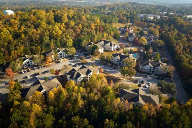 Güney Carolina 'nın banliyö bölgesindeki sarı sonbahar ağaçları arasındaki apartman dairelerinin üstünden bak. Amerikan banliyölerinde emlak gelişimine örnek olarak Amerikan evleri.