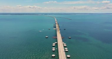 Florida 'daki Tampa Körfezi üzerinde Sunshine Skyway Köprüsü' nde araba sürüyor. Amerika 'da ulaşım altyapısı.
