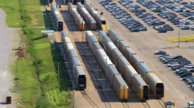 Otomotiv fabrikasının otoparkına dünya çapında ihracat yapmak için kargo trenine yüklenen yeni arabalar. Dağıtıcı araç envanteri ticareti