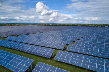 Temiz elektrik enerjisi üretmek için sıra sıra güneş fotovoltaik panelleri olan sürdürülebilir büyük elektrik santralinin havadan görünüşü. Sıfır emisyonlu yenilenebilir elektrik kavramı.
