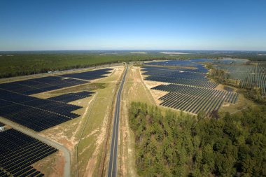 Temiz elektrik enerjisi üretmek için sıra sıra güneş fotovoltaik panelleri olan sürdürülebilir büyük elektrik santralinin havadan görünüşü. Sıfır emisyonlu yenilenebilir elektrik kavramı.