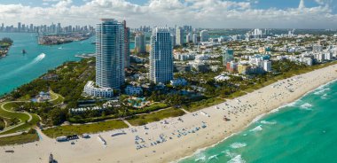 Sıcak Florida güneşinde dinlenen turistlerle birlikte güney sahilinin kumlu yüzeyi. Yüksek lüks otelleri ve apartmanları olan Miami Beach City. Güney Amerika 'da turizm altyapısı.