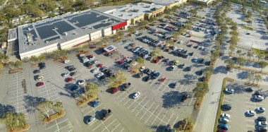 Florida 'da bir alışveriş merkezinin önündeki otoparkta park edilmiş birçok arabanın üst görüntüsü. Kentsel ulaşım kavramı.