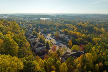 Güney Carolina 'nın banliyö bölgesindeki sarı sonbahar ağaçları arasındaki apartman dairelerinin üstünden bak. Amerikan banliyölerinde emlak gelişimine örnek olarak Amerikan evleri.