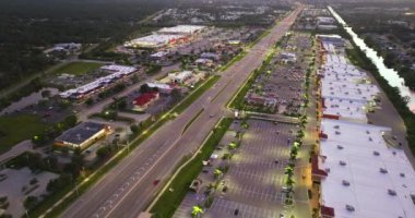 Gün batımında alışveriş merkezleri. Kuzey Port, Florida 'da ışıklı yol ve sürüş arabaları. ABD 'nin perakende ve ulaştırma altyapısının üzerinden görüntüle.