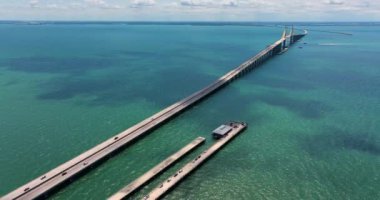 Florida 'daki Tampa Körfezi üzerinde Sunshine Skyway Köprüsü' nde araba sürüyor. Amerika 'da ulaşım altyapısı.