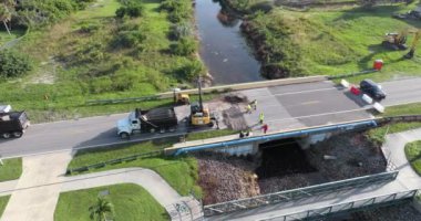 Yol çalışması alanında inşaat malzemeleri. Sel suları asfaltı temizledikten sonra nehir tarafından yıkılan hasarlı yol köprüsünün yeniden inşası