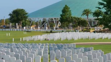 Amerikan askeri mezarlığı. Yeşil çimlerin üzerinde beyaz mezar taşları var. Anma Günü konsepti.