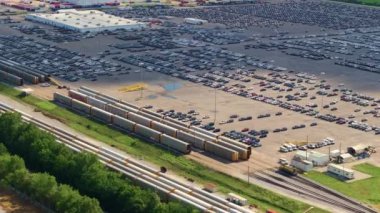 Otomotiv fabrikasındaki sanayi yük treni nakledilmeye hazır yeni arabalarla dolu. Satılık araçları olan otomobil üreticisi otoparkı