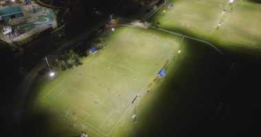 İnsanlar geceleri halka açık stadyumda futbol oynuyorlar. Aktif yaşam konsepti.