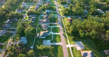 Florida 'daki küçük Amerikan kasabasında kırsal yol trafiği. Yeşil ağaçlar ve sakin yerleşim alanlarındaki banliyö sokakları arasında özel evler var.