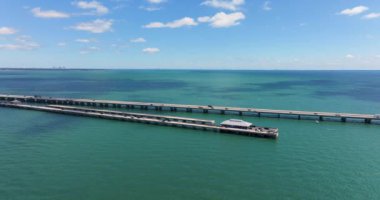 Florida 'daki St. Petersburg' da Tampa Körfezi üzerinde balıkçı iskelesi ve trafik arabaları olan Sunshine Skyway Köprüsü. ABD 'de ulaşım altyapısı.
