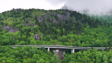 Yaz yağmuru mevsiminde Blue Ridge Parkway 'deki Linn Cove Viaduct. Kuzey Carolina Appalachian dağlarındaki dağ köprüsü, ABD.