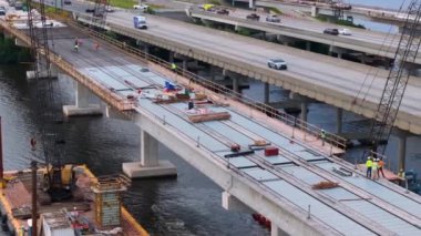Ellenton, Florida 'da inşa edilen köprü açıklıklarıyla birlikte endüstriyel inşaat işlerinde çalışan adamlar. Eyaletler arası ulaşımın geliştirilmesi.