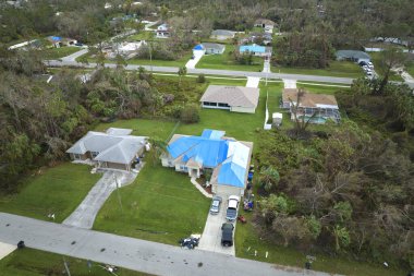 Ian Kasırgası 'nın çatısı, asfalt kiremitleri değişene kadar yağmur suyuna karşı mavi korumalı muşambayla kaplıydı..