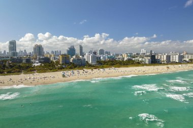 Sıcak Florida güneşinde dinlenen turistlerle birlikte güney sahilinin kumlu yüzeyi. Yüksek lüks otelleri ve apartmanları olan Miami Beach City. Güney Amerika 'da turizm altyapısı.