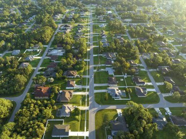Küçük bir kasabada sokak trafiğinin hava görüntüsü. Florida 'da sakin yerleşim bölgesinde yeşil palmiye ağaçları arasında özel evleri olan Amerikan banliyö manzarası.